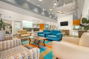 A modern hotel lobby with seating areas, a concierge desk, and a TV mounted on the wall. - Hilton Vacation Club Palm Canyon Palm Springs (Palm Springs)
