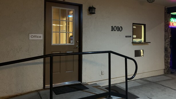 A building entrance with a door labeled "Office," a number "1010" on the wall, and a small window. - Regency Inn (Lakeport)