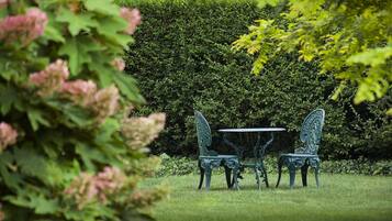 A garden with a table and two chairs.