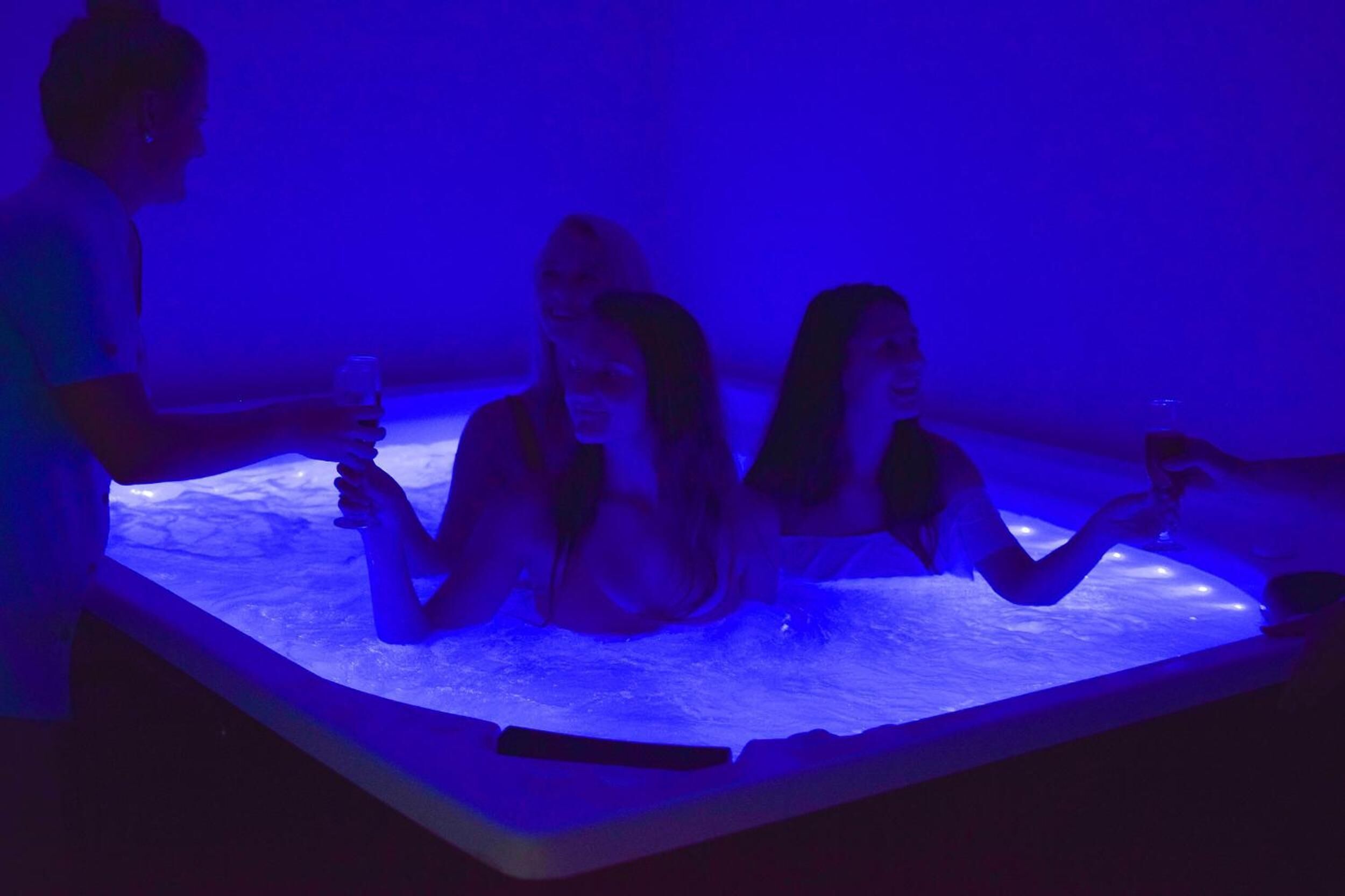 A group of people in a room with a blue-lit water feature.