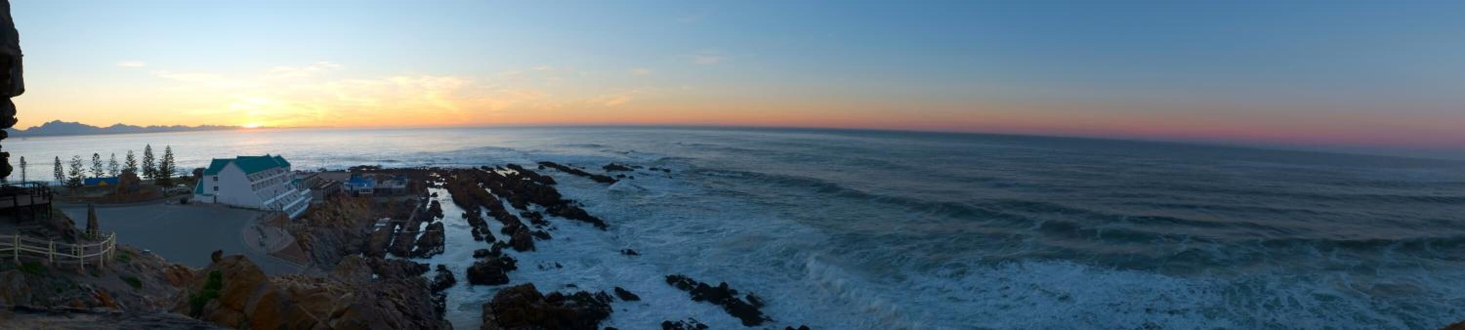 Un paisaje costero con formaciones rocosas y una vista despejada del mar.