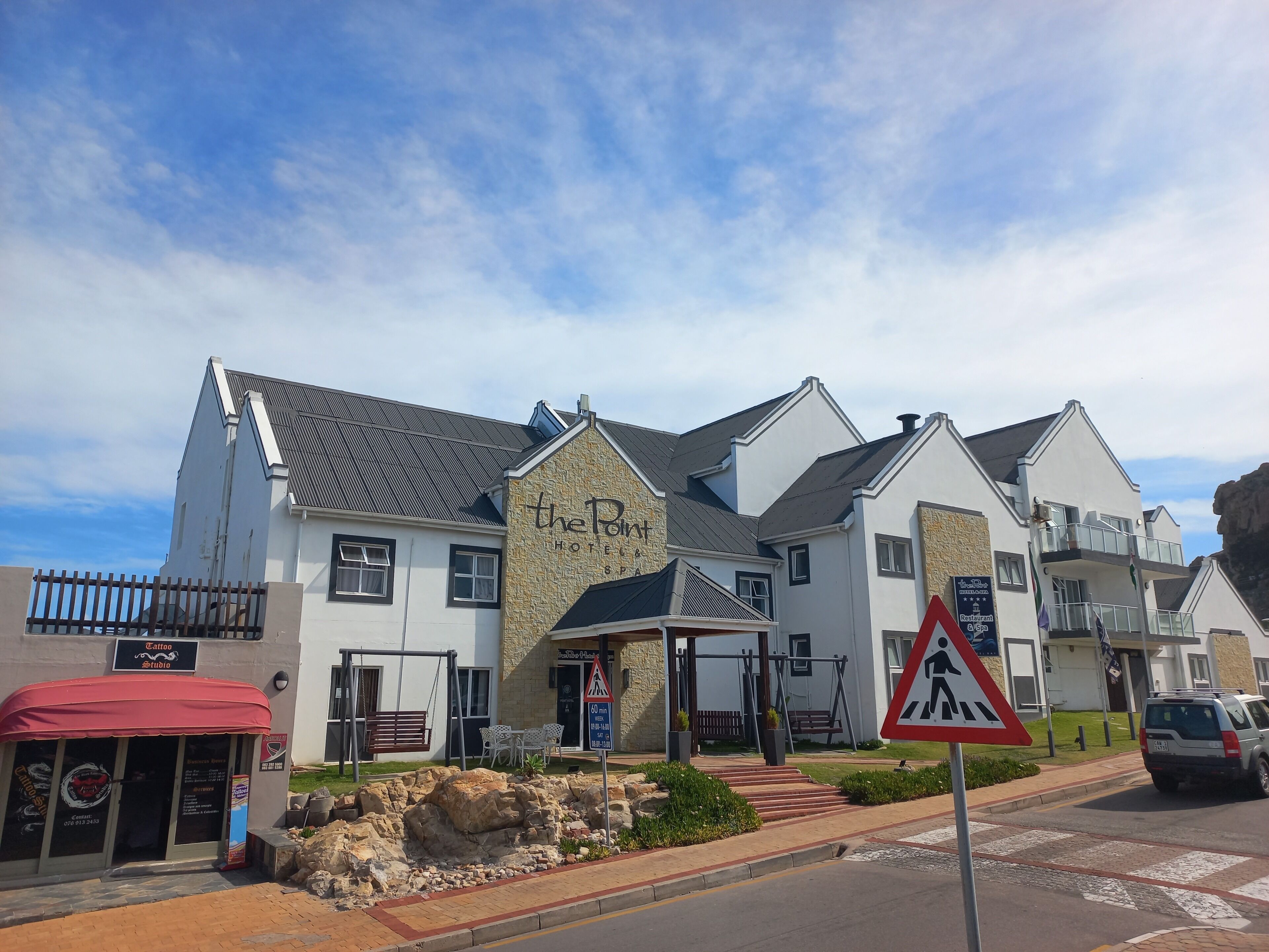 Ett hotell med en fasad av sten, många fönster och en skylt med texten ”The Port Hotel SPA”.