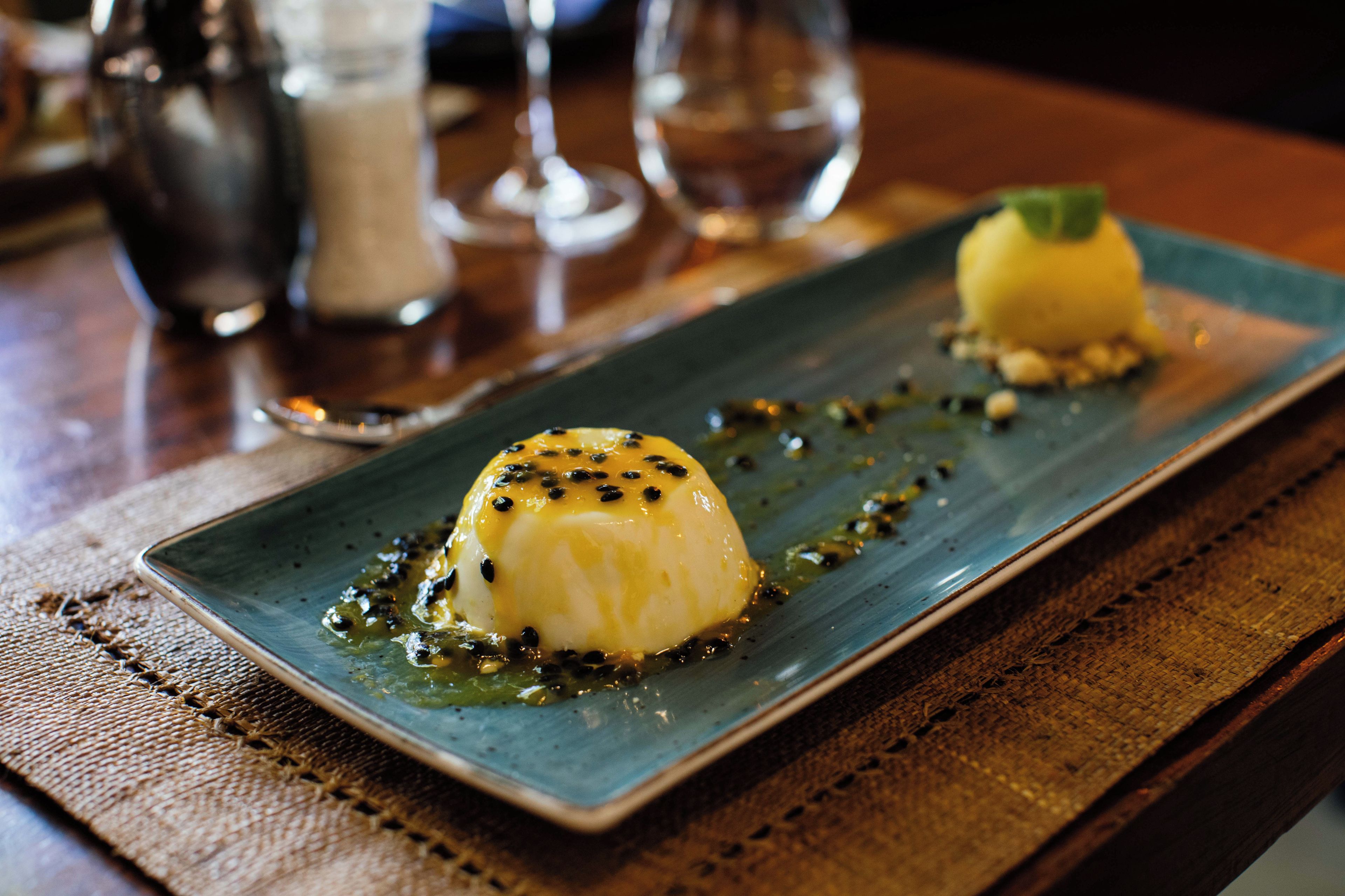 Un postre sobre un plato rectangular con un mantel texturizado.