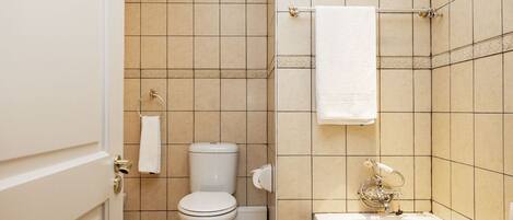 A bathroom with a toilet, sink, and bathtub.