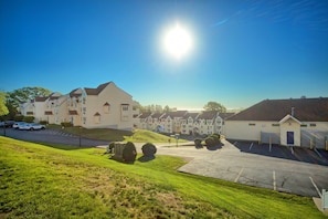 Zona residencial con varios edificios de apartamentos, un estacionamiento y una zona con césped.