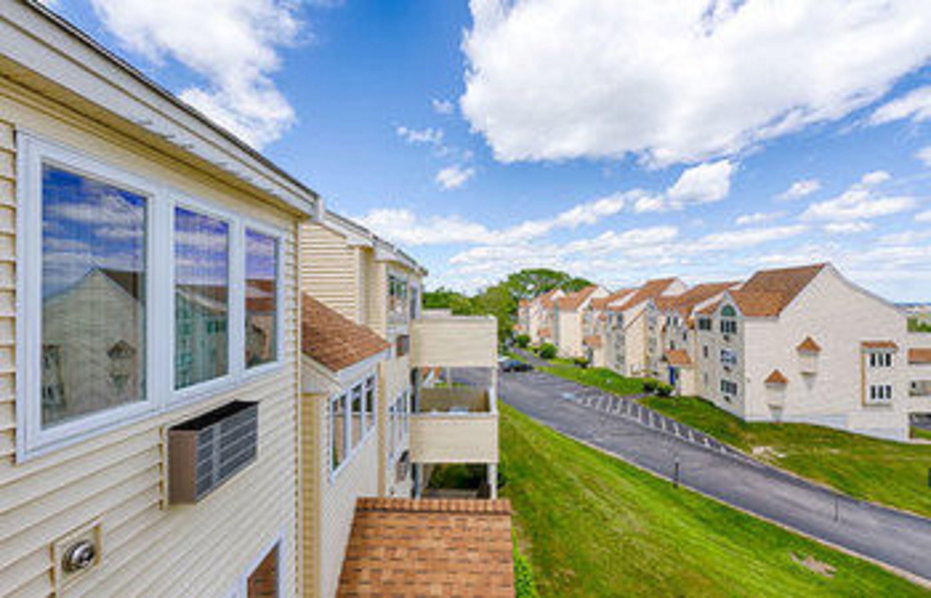 A row of single-story houses with a street in front.