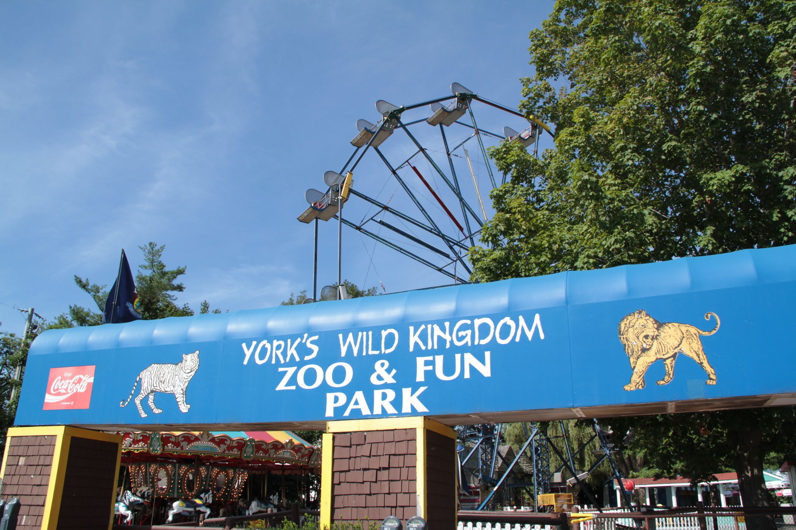 York's Wild Kingdom Zoo & Fun Park entrance sign with a roller coaster in the background.