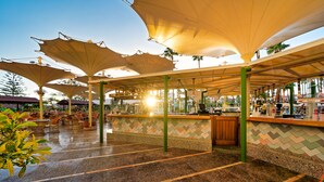 A covered outdoor seating area with a bar and chairs. - Bull Eugenia Victoria & Spa (San Bartolomé de Tirajana)