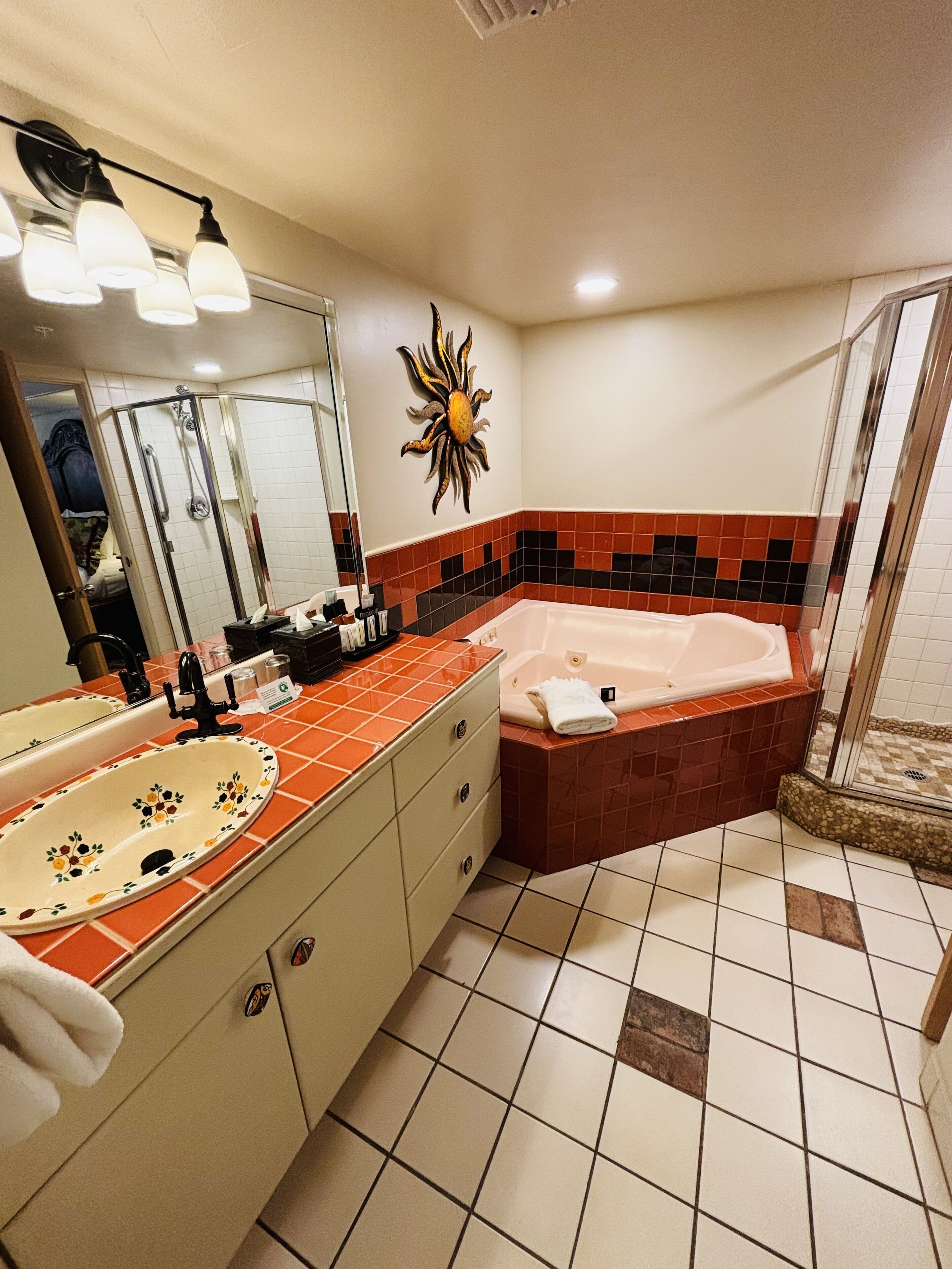 Une salle de bain dotée d’une grande baignoire, d’un lavabo double et d’un espace douche.