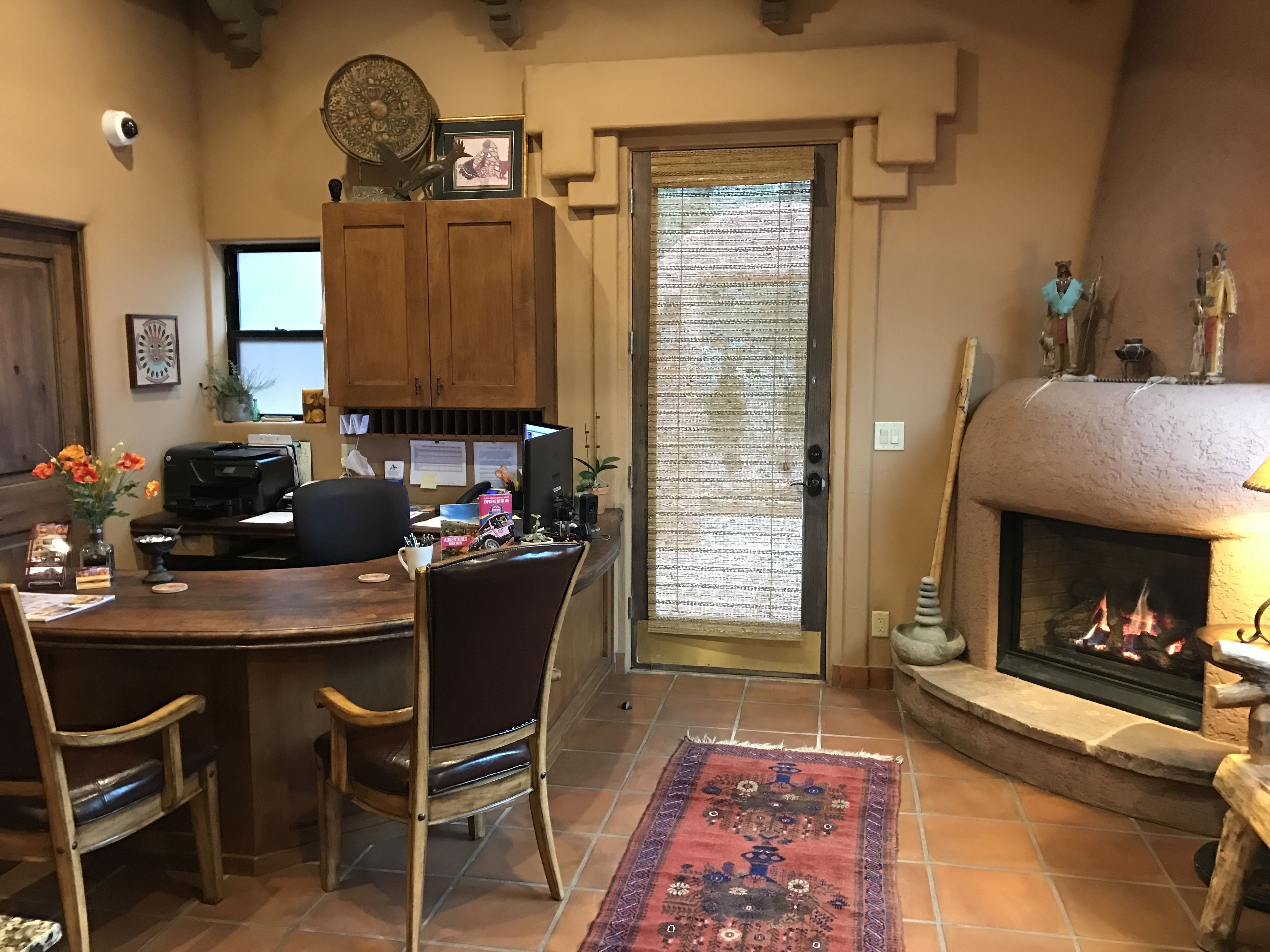 Un intérieur chaleureux avec une cheminée, des meubles en bois et un sol carrelé.