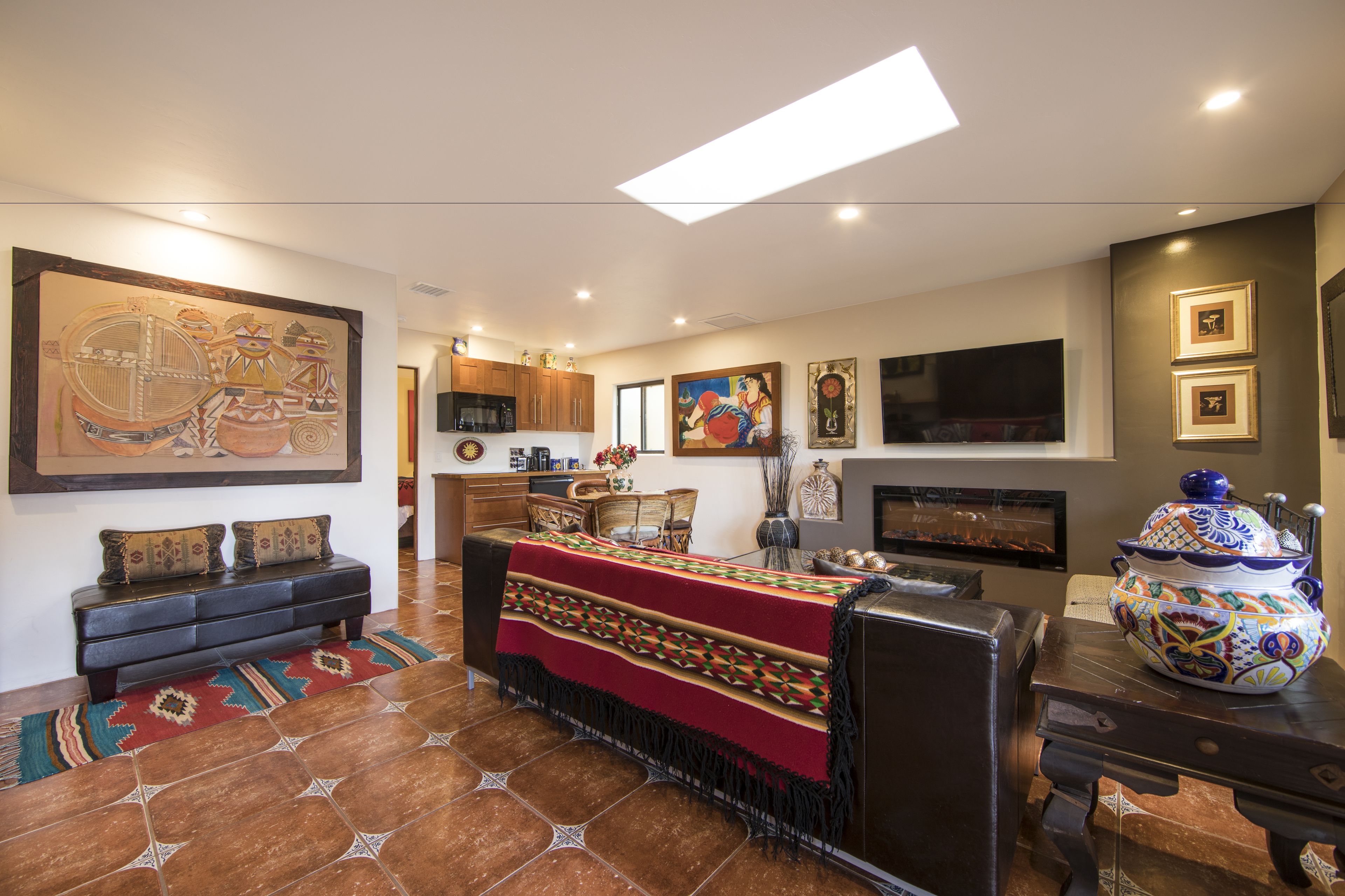 A modern living room with a fireplace, a large painting, and a coffee table.