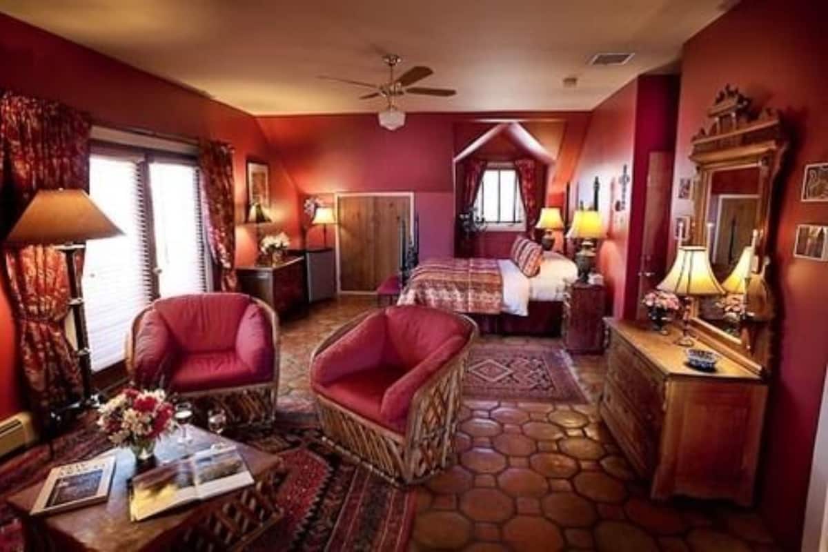 Une chambre d’hôtel avec un lit, une chaise, un bureau et une commode.