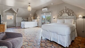 Une chambre avec deux lits, un sol imitant le motif de la pierre, un lustre et une tête de lit décorative.