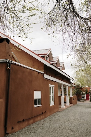 Een gebouw met een bruine gevel, witte ramen en een rood dak.