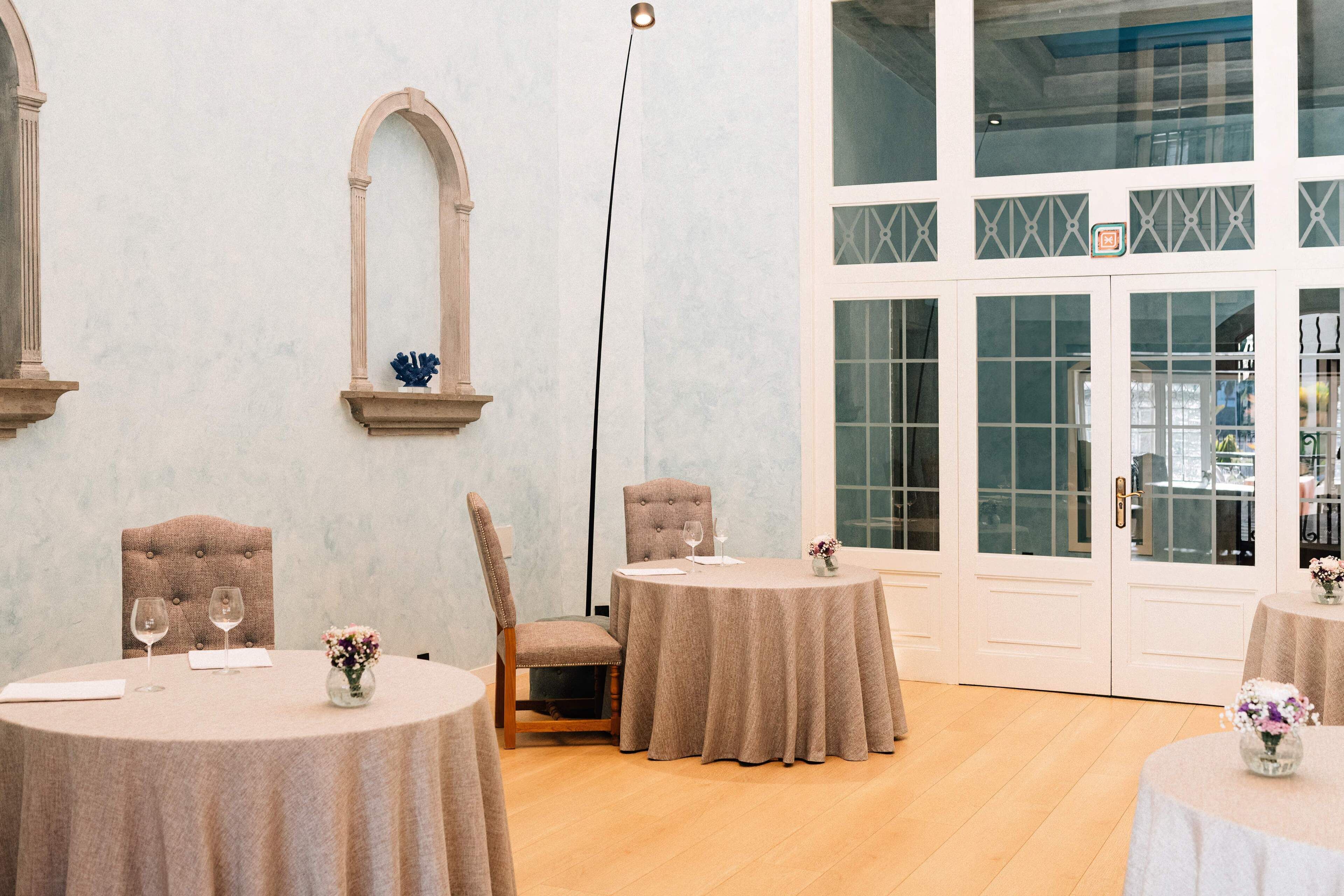 Un espace repas avec des tables rondes, des chaises et un grand lampadaire.