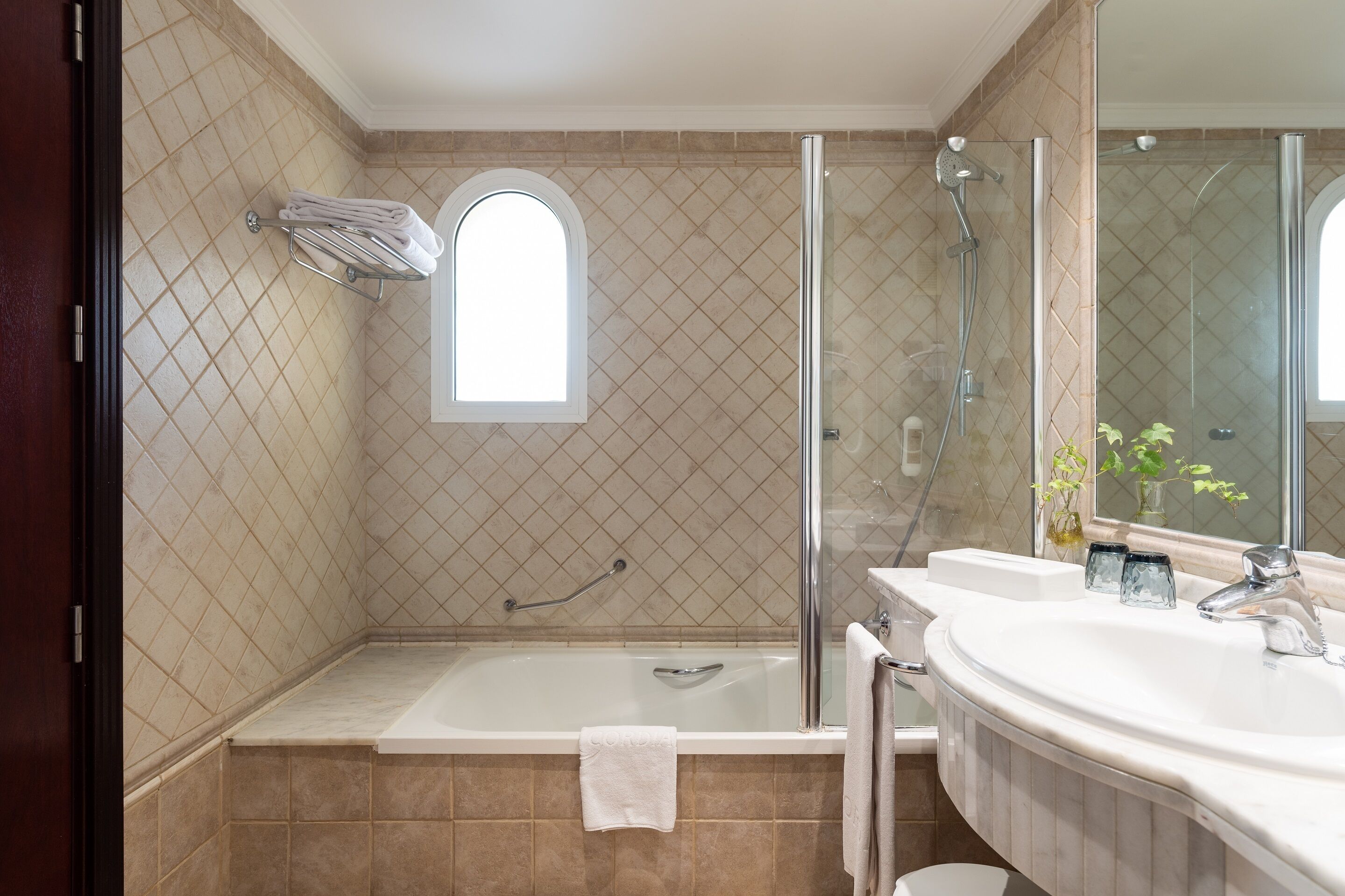 Ein Badezimmer mit einer Duschkabine, einer Badewanne und einem Waschtisch mit Waschbecken und Spiegel.