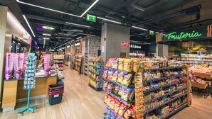 A supermarket aisle with various snack and grocery items on shelves. - Servatur Puerto Azul (Mogan)