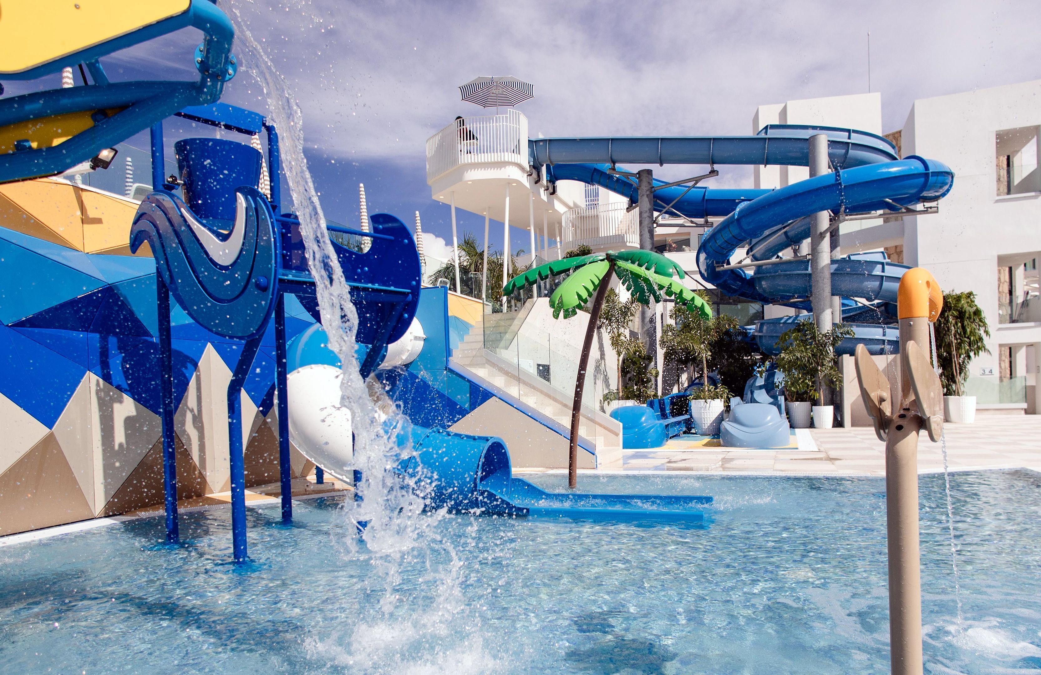 Un parque acuático con múltiples toboganes y atracciones, incluyendo una piscina de olas y un tobogán de agua.