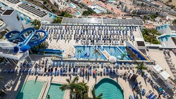 Vista aérea de um resort com várias piscinas, parque aquático e espreguiçadeiras.