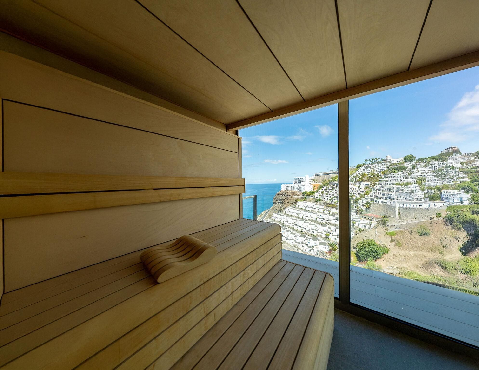 A wooden bench with a view of a coastal town.