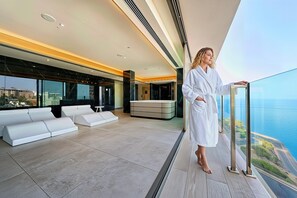 A modern interior with a large window overlooking a body of water, a seating area, and a minimalist design. - Servatur Puerto Azul (Mogan)