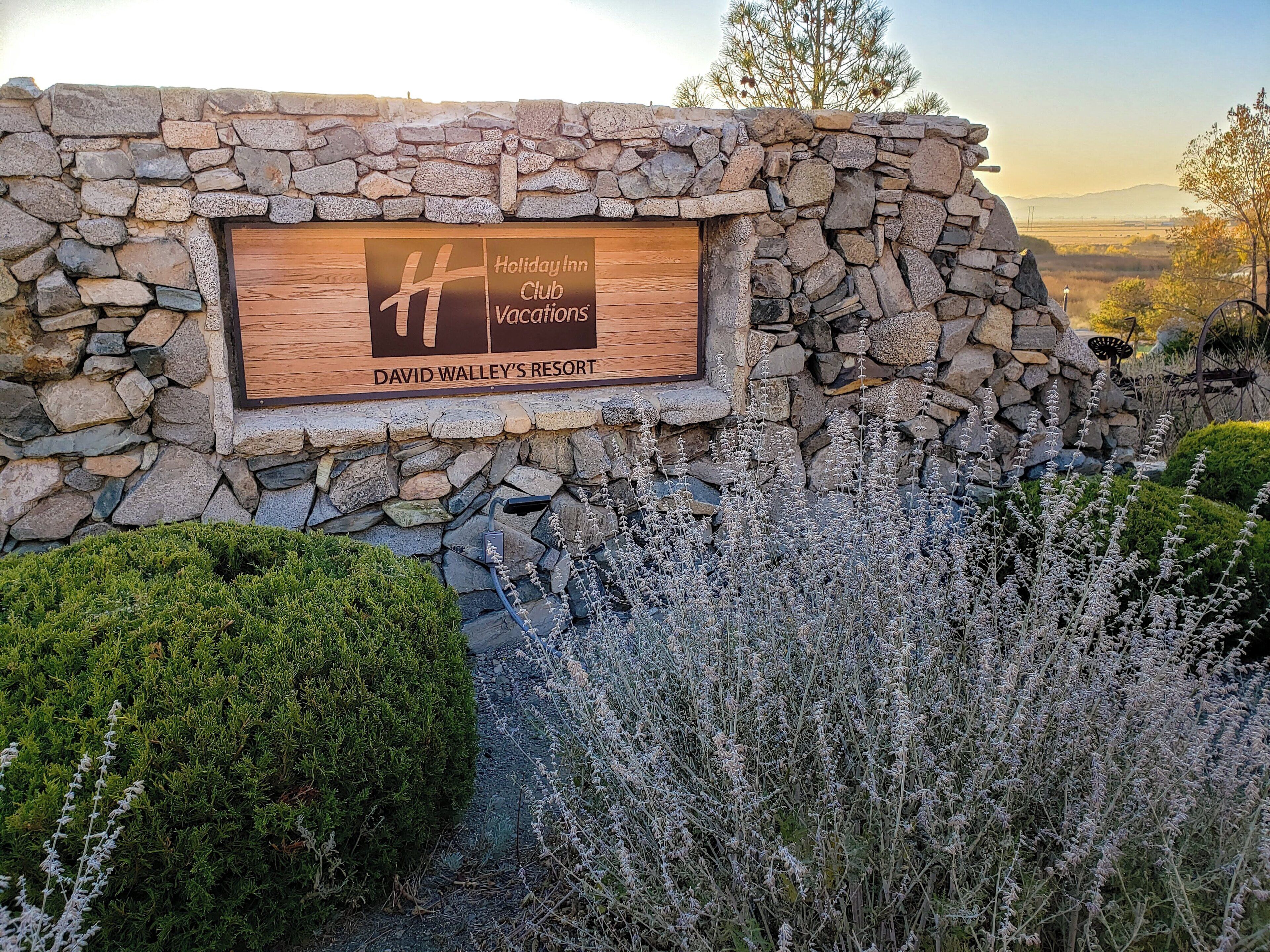 A stone wall with a wooden sign for the Holiday Inn Club Vacations at David Valley's Resort.