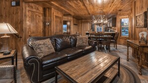 A cozy living room with a leather sofa, wooden coffee table, and a dining area with a chandelier. - Holiday Inn Club Vacations David Walley's Resort by IHG (Genoa)