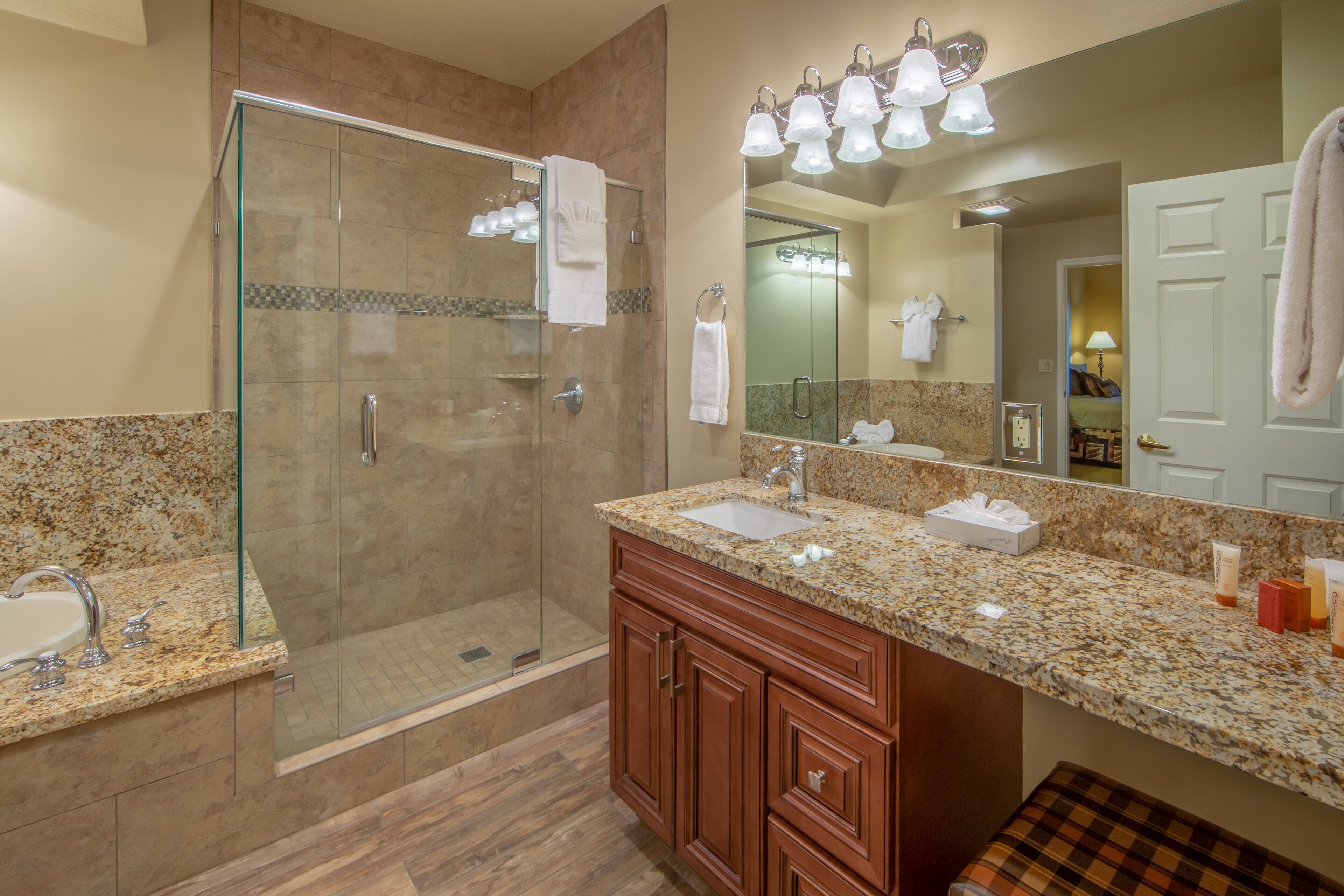 A modern bathroom with a glass-enclosed shower, a sink, and a vanity with a mirror.