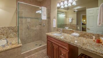 A modern bathroom with a glass-enclosed shower, a sink, and a vanity with a mirror.