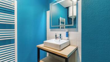 A bathroom with a white sink, a mirror, and a towel rack.