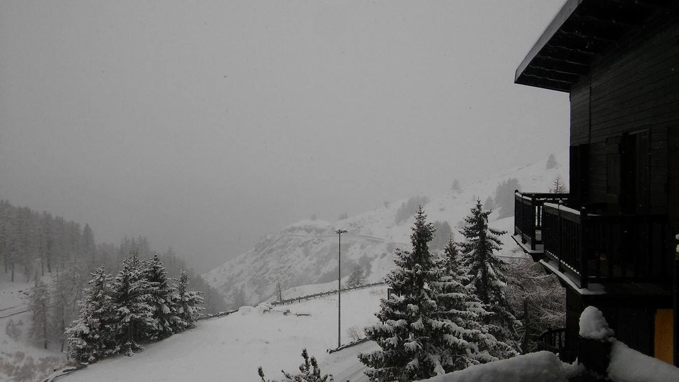 A snowy mountain landscape with a wooden building on the right.