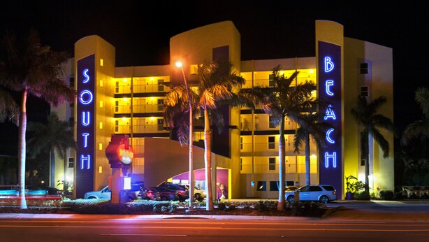 A hotel with a modern design, featuring a prominent 'South Beach' sign and a 'Beach' sign.