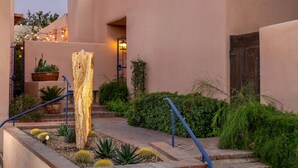 A building with a stucco exterior, a wooden post, and a brick pathway with railings. - Adobe Rose Inn B&B (Tucson)