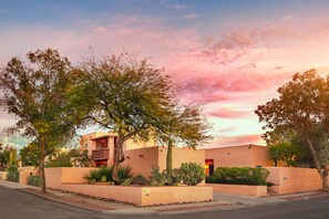 A residential building with a flat roof, a balcony, and a well-maintained garden with cacti and shrubs. - Adobe Rose Inn B&B (Tucson)