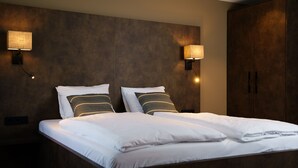A hotel room with a large bed, two bedside lamps, and a wardrobe. - Hampshire Hotel - Voncken Valkenburg (Valkenburg aan de Geul)