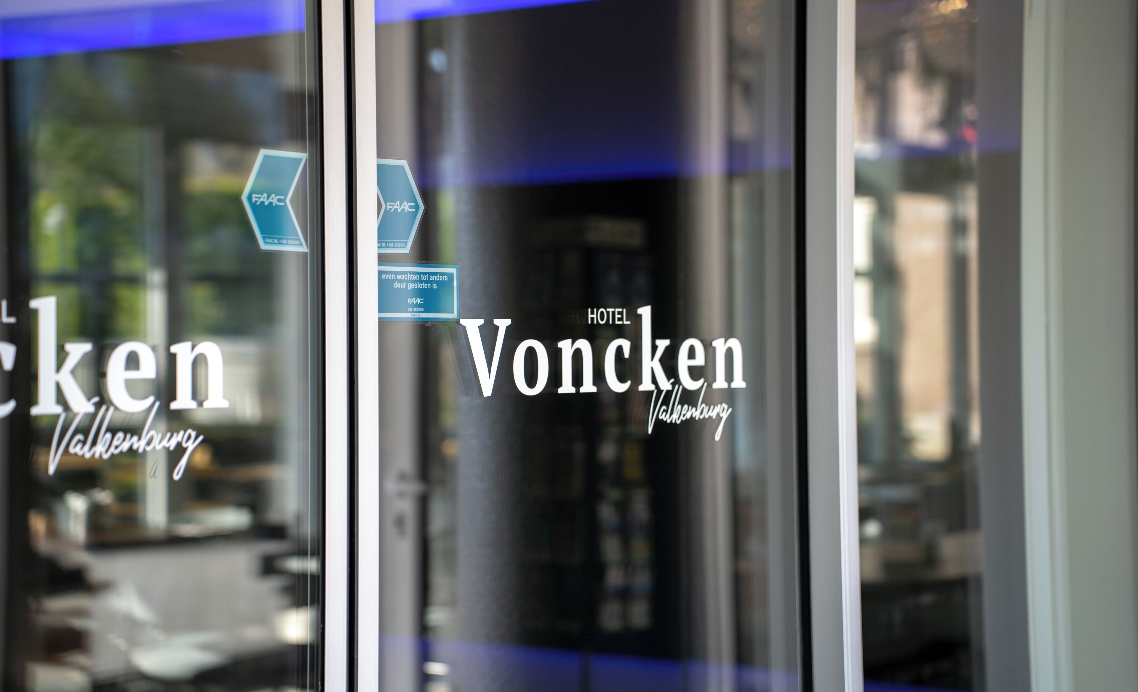 A hotel sign with 'HOTEL 1 Voncken Valkenburg' and a partial view of the interior.
