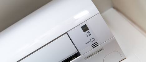 Un equipo de aire acondicionado blanco con pantalla digital y botones de control.