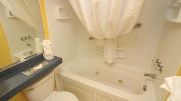 A bathroom with a bathtub, toilet, and a sink with a towel rack.