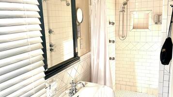 Un baño con lavamanos, espejo y ducha.
