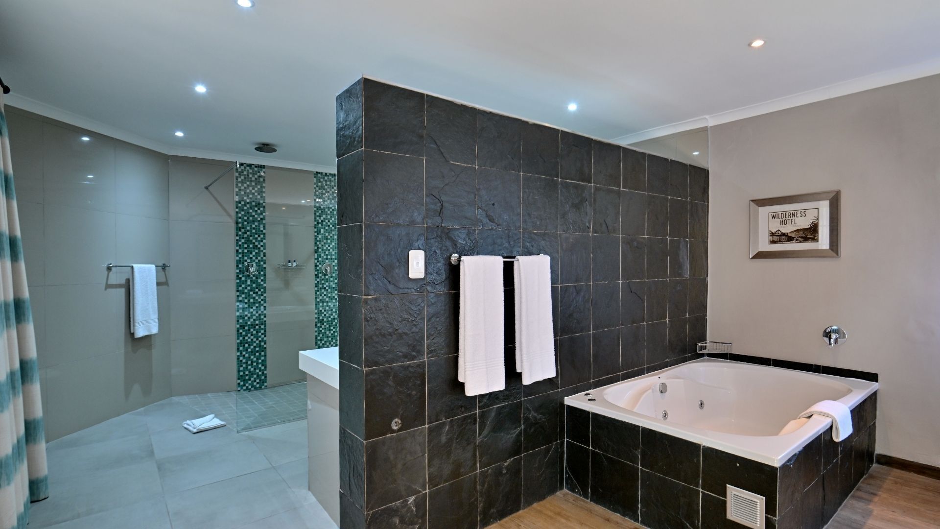 A modern bathroom with a large bathtub, a shower area, and a glass-enclosed shower.