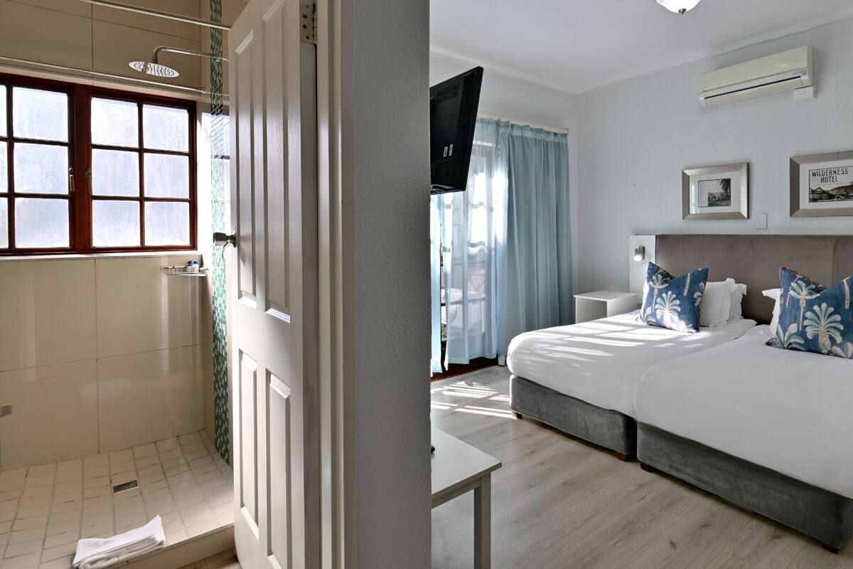 Une chambre d’hôtel avec un grand lit, une télévision, une douche et une vue sur l’extérieur.