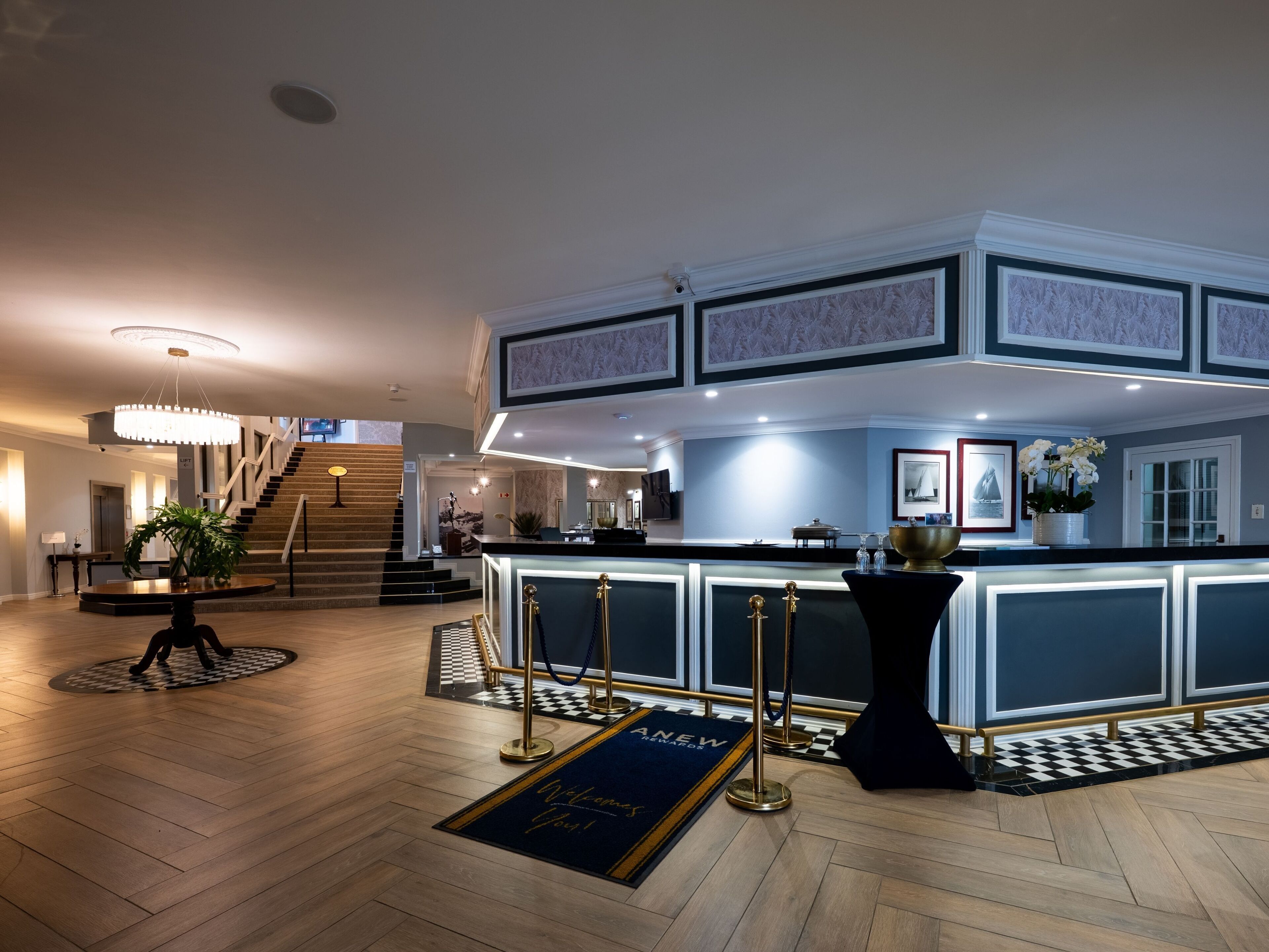Un vestíbulo de hotel con una recepción, una escalera y un mostrador de check-in.