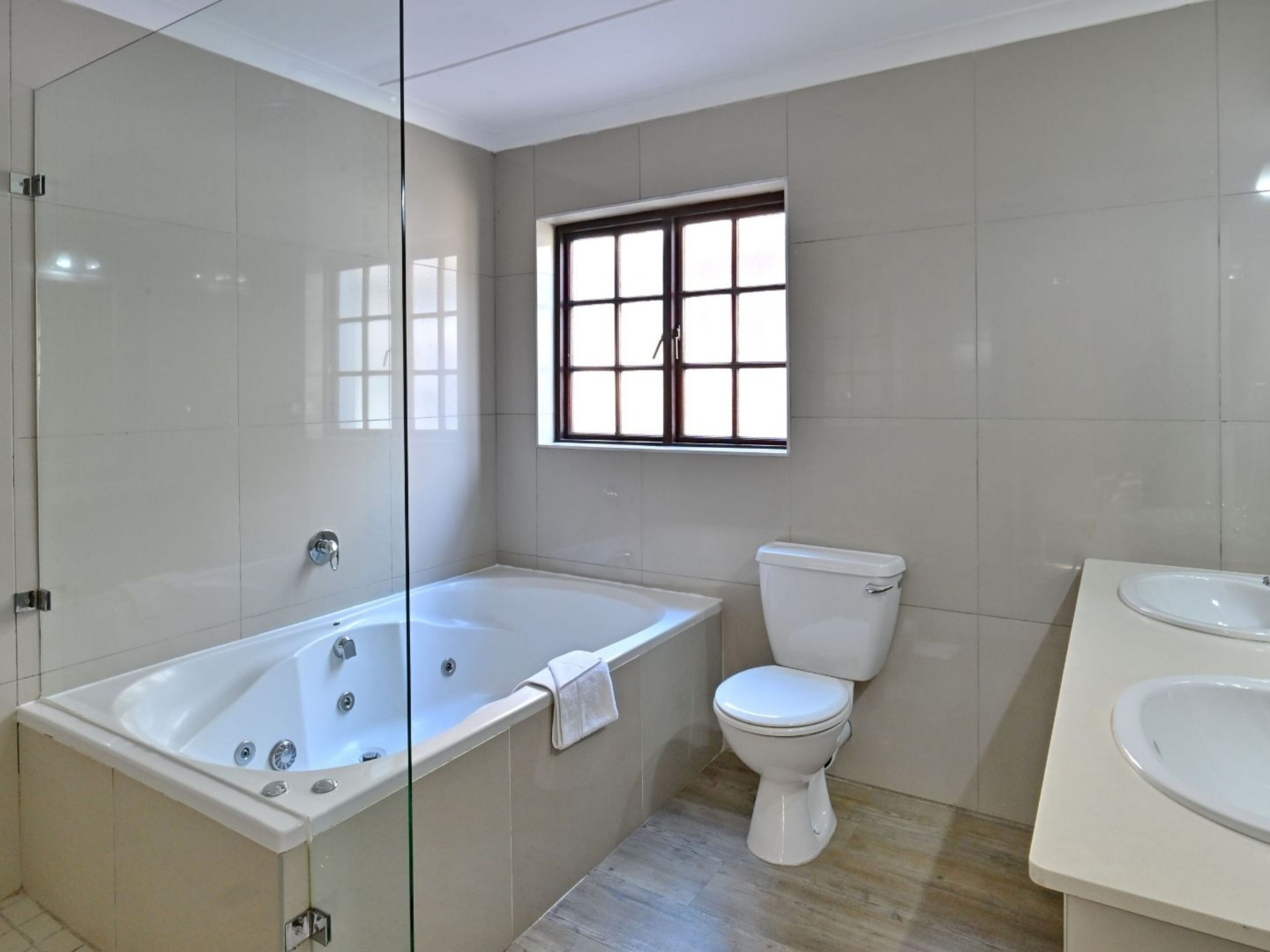Ein modernes Badezimmer mit einer Glasdusche, einer freistehenden Badewanne, einer Toilette und einem Waschbecken.