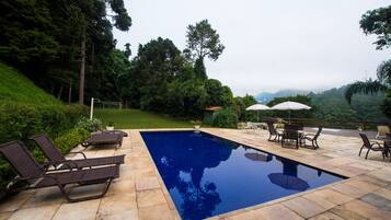 Alberca al aire libre y camastros