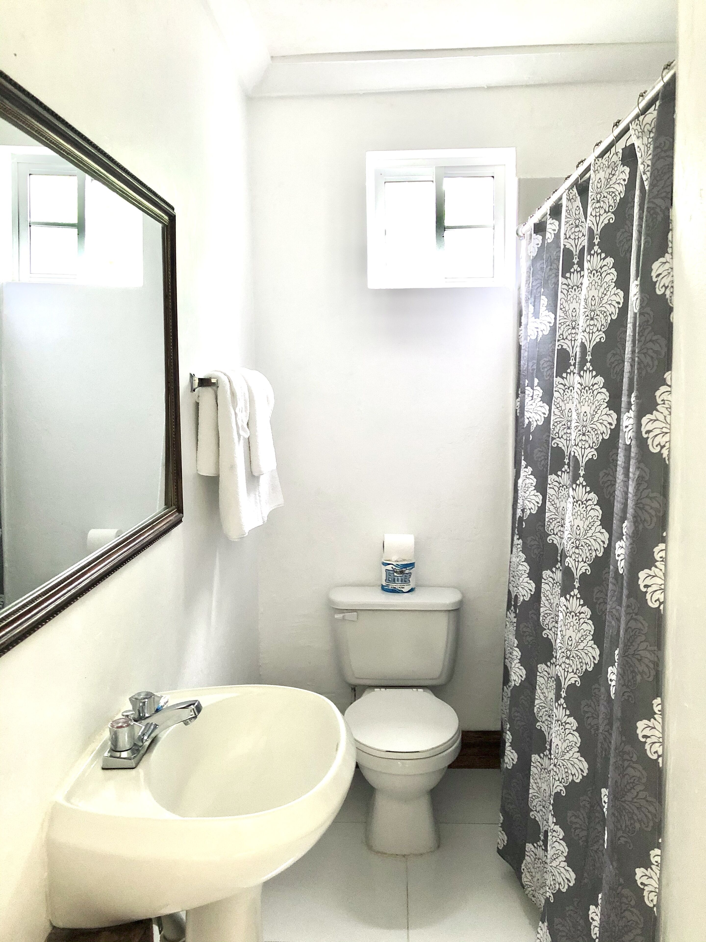 A small bathroom with a white sink, a toilet, and a mirror.