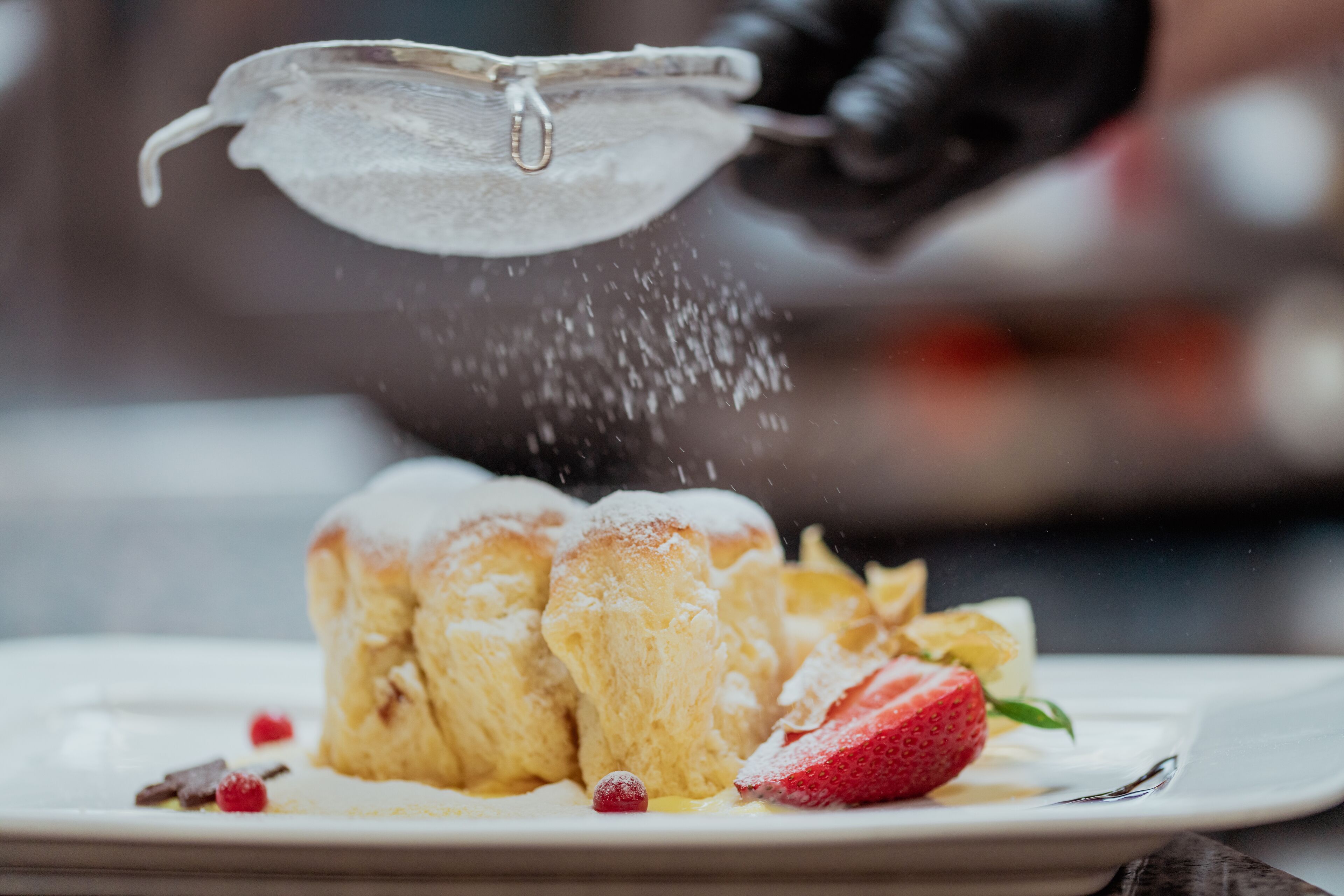 Un postre con crema batida y fresas en un plato.