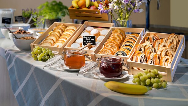 A buffet table with various food items and a jar of jam.
