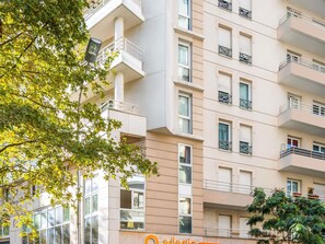 A multi-story building with balconies, large windows, and a sign indicating it is a hotel. - Aparthotel Adagio Access La Défense Place Charras (Courbevoie)