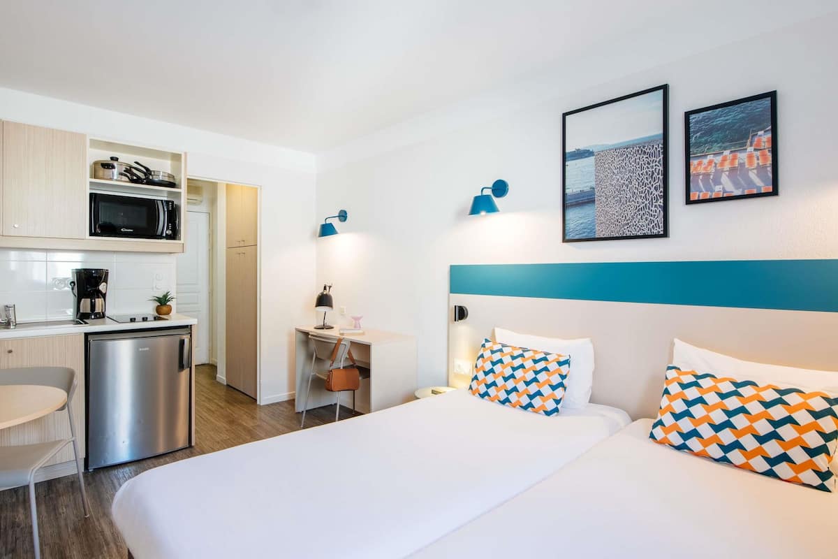 Studio, 2 lits une place | Coffres-forts dans les chambres, ameublement personnalisé, bureau