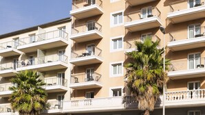 A multi-story hotel with balconies, palm trees, and a clear sky. - Aparthotel Adagio Access Nice Magnan (Nice)